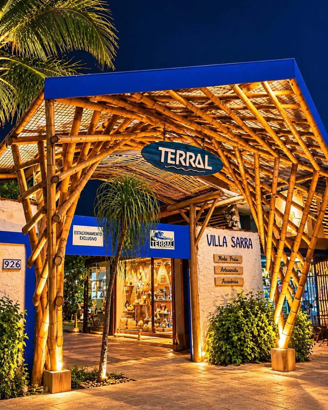 Fachada iluminada do Restaurante Terral Maresias à noite com estrutura de bambu